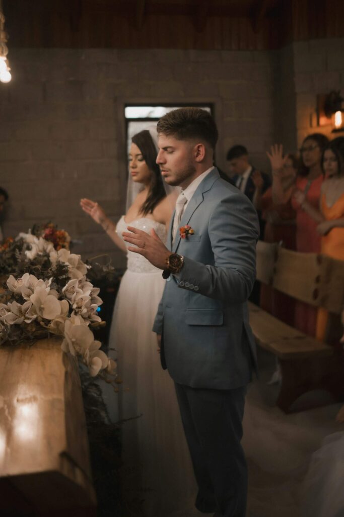 Brudpar star vid altaret under vigselceremoni inomhus.