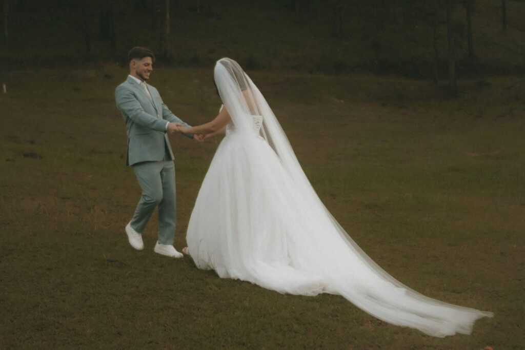 Brudpar haller varandra i handen pa en ang