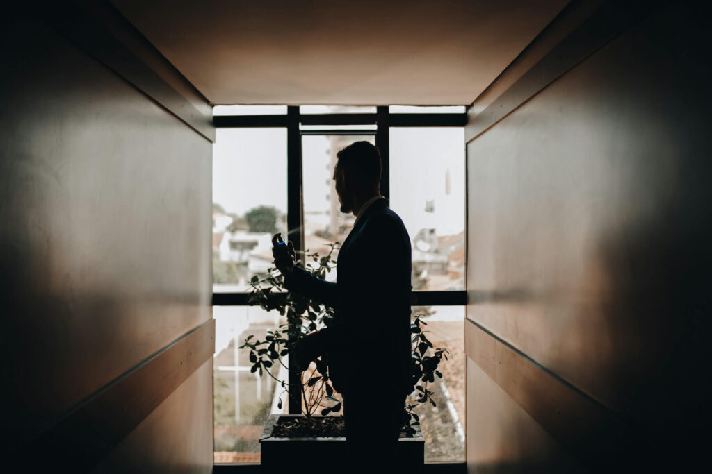 Brudgum star vid fonster under forberedelserna.