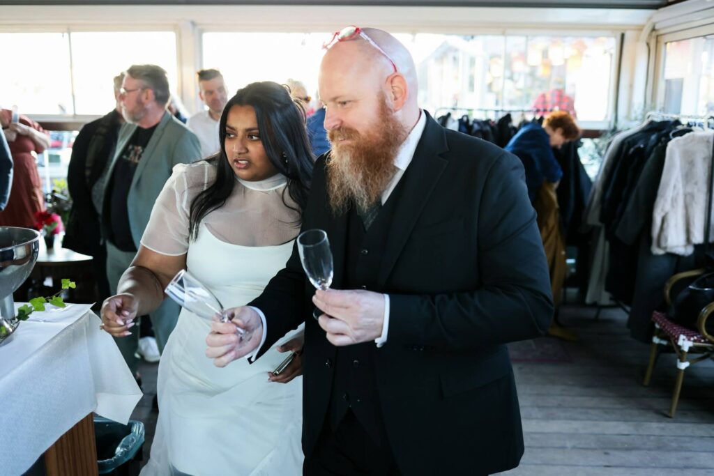 Brudpar firar med champagne under bröllop i Skåne