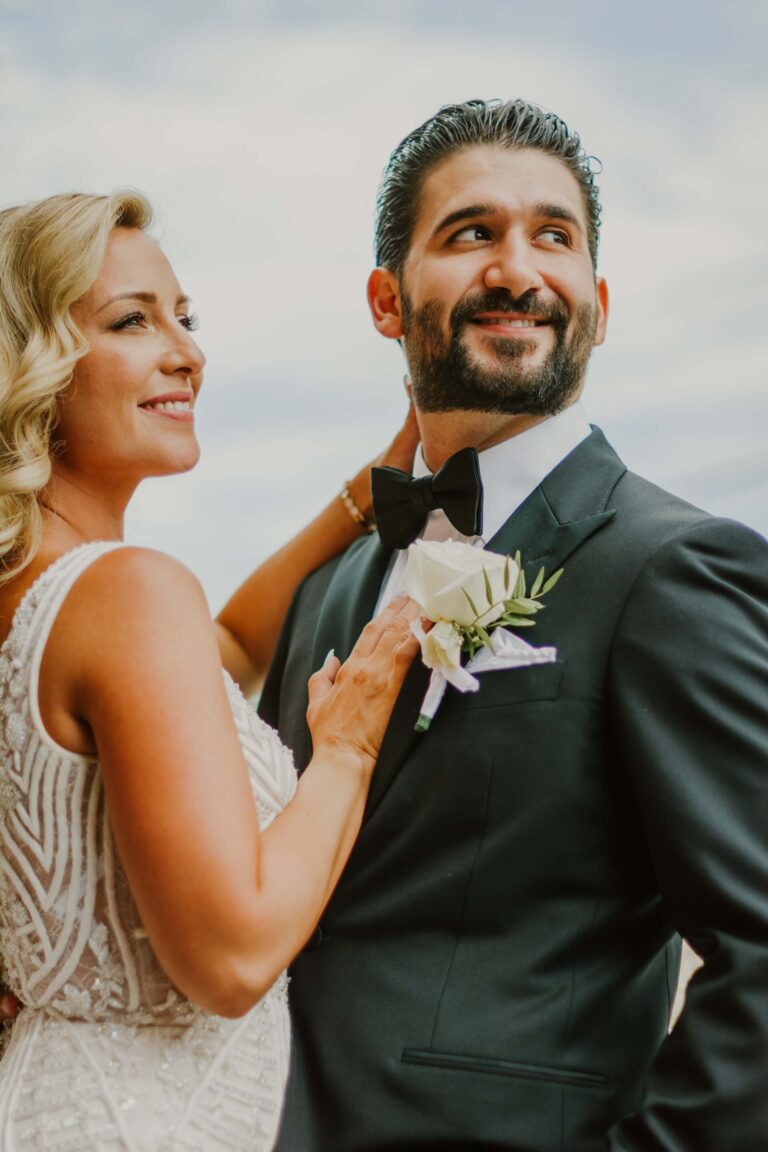 Närbild där bruden håller handen mot brudgummens axel under ett romantiskt ögonblick