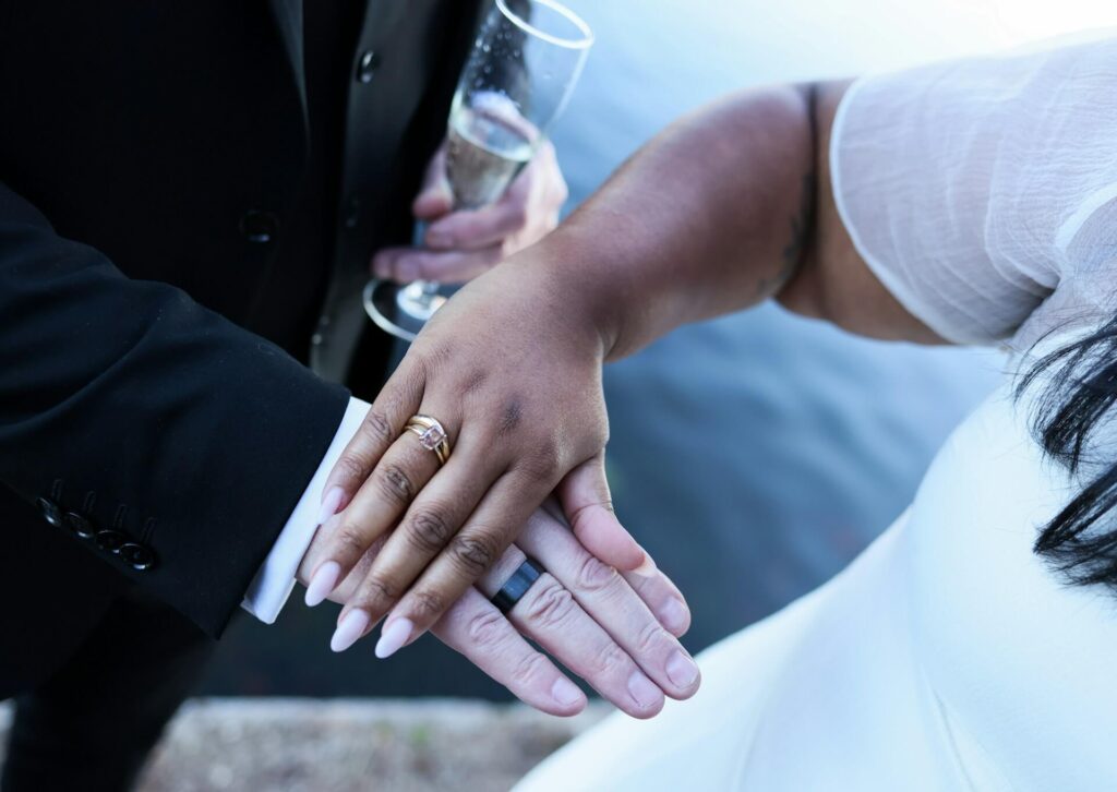 Vigselringar på brudparets händer under bröllop i Skåne